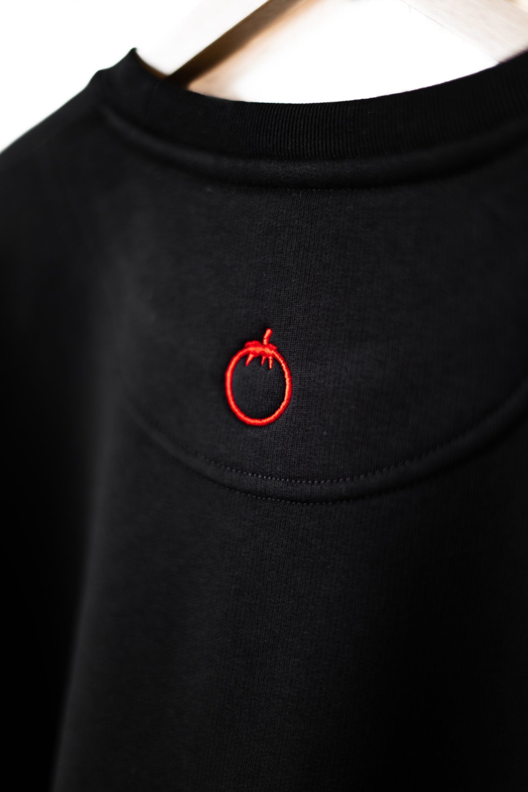 Zoom sur le col rond et la broderie du dos, du sweat noir Nero Paolo.